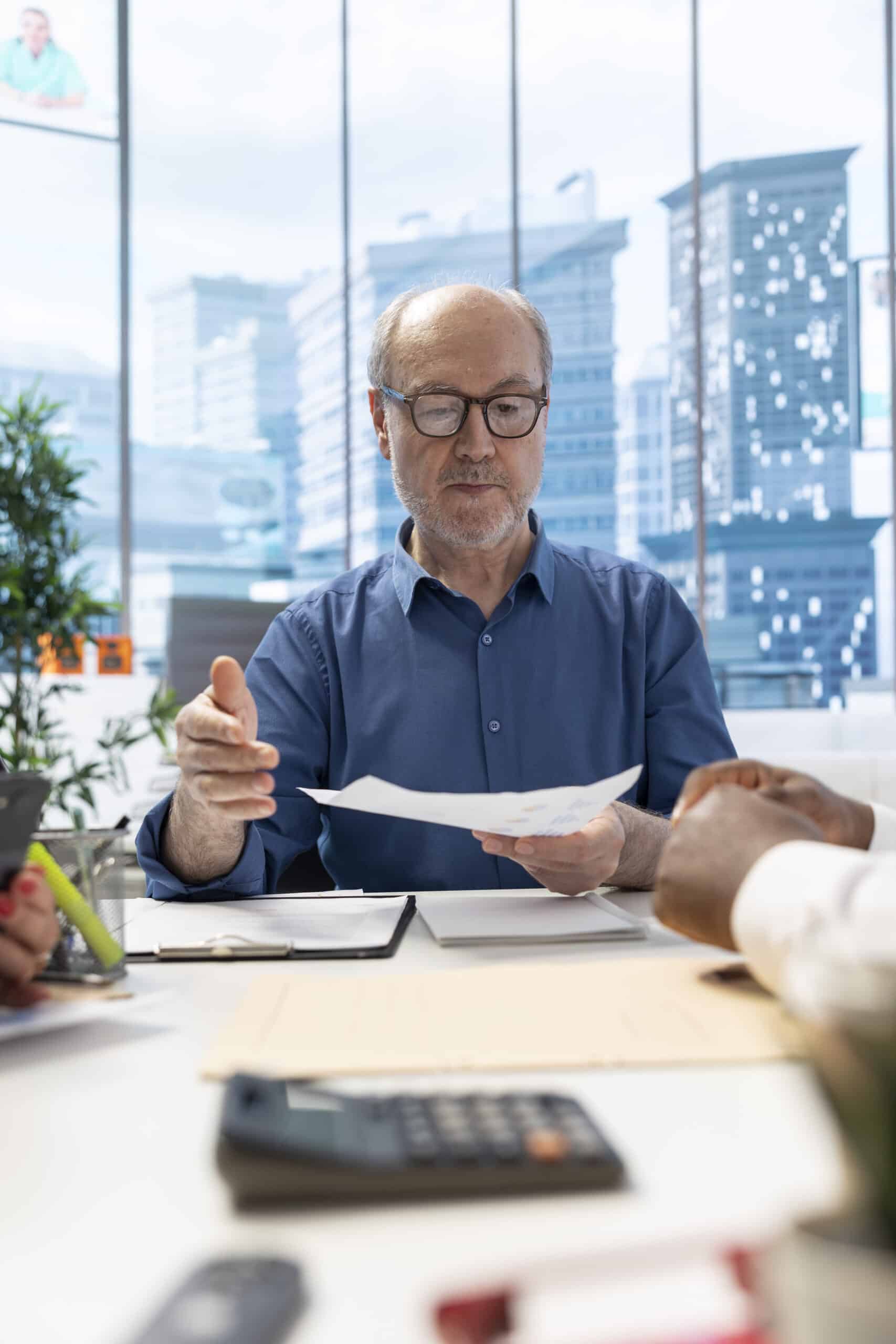 Senior people negotiating with a financial banker to develop a pension plan, focusing on their savings and long term financial stability. Clients discussing a retirement option.